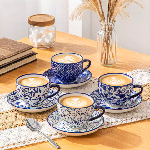 Set of 4 Selene indigo floral porcelain cups and saucers on a wooden table with coffee and pastries featuring blue and white Japanese style mix and match patterns