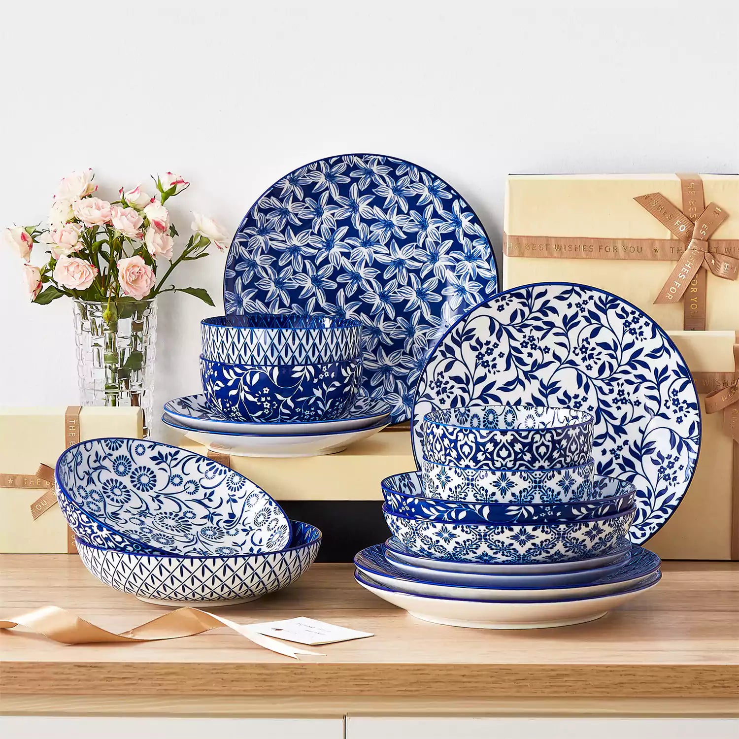 Selene 16-piece porcelain set with indigo floral and geometric patterns on plates - bowls - and mugs displayed on a dining table