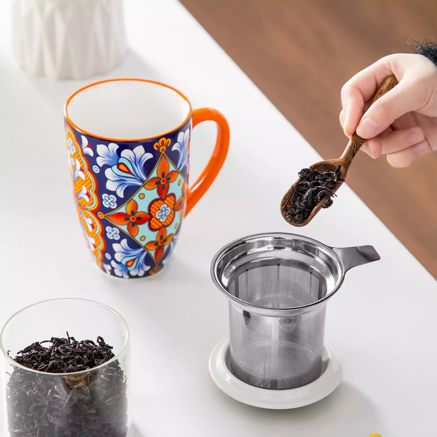 Simi tea mug with infuser and lid colorful bold orange boho chic ceramic coffee cup with spoon and loose tea leaves on white background