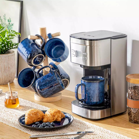 Starry gently curved blue mugs set of 6 displayed on a wooden table with a coffee maker and a plate of pastries