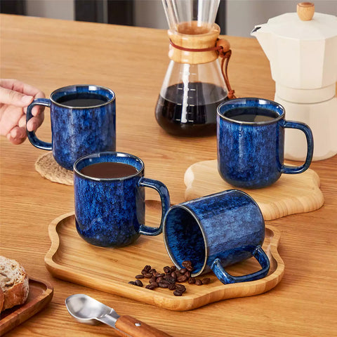 Starry blue 12oz stoneware mugs set of 4 with coffee on wooden table next to coffee maker and fresh bread cozy breakfast scene
