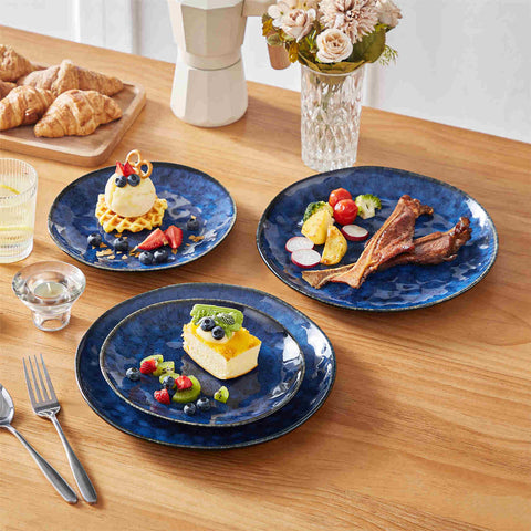 Starry 12-piece stoneware dinnerware set in blue on a light wooden table - styled with lamb chops - pastries - coffee pot - and lemon water for a cozy farmhouse breakfast scene