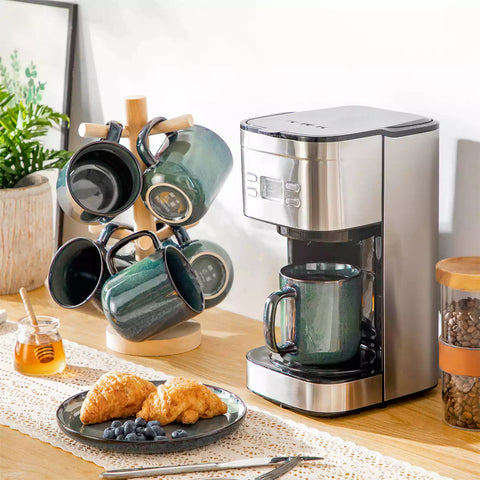 Starry gently curved green mugs set of 6 displayed on a wooden table with a coffee maker and a plate of pastries
