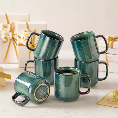 Starry gently curved green mugs set of 6 displayed on a wooden table with a coffee maker and a plate of pastries