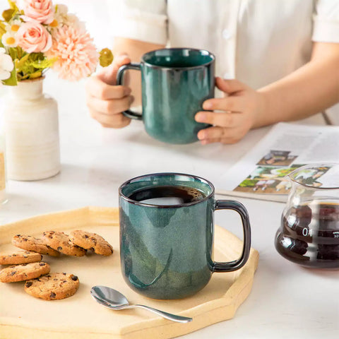 Starry gently curved green mugs set of 6 displayed on a wooden table with a coffee maker and a plate of pastries