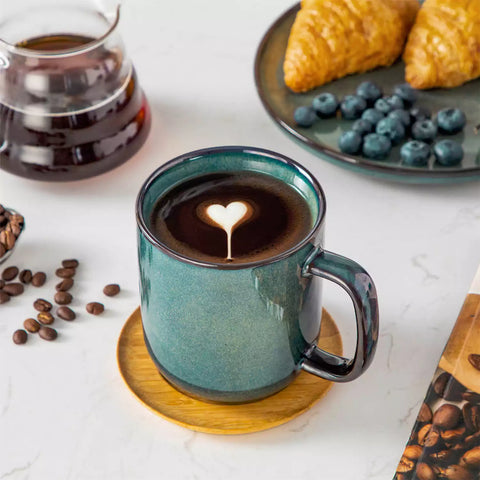 Starry gently curved green mugs set of 6 displayed on a wooden table with a coffee maker and a plate of pastries