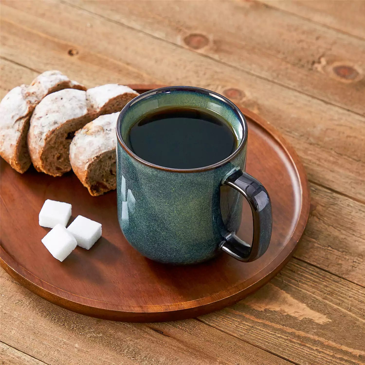 Four starry green 16oz stoneware mugs with latte art on wooden table beside coffee brewing equipment