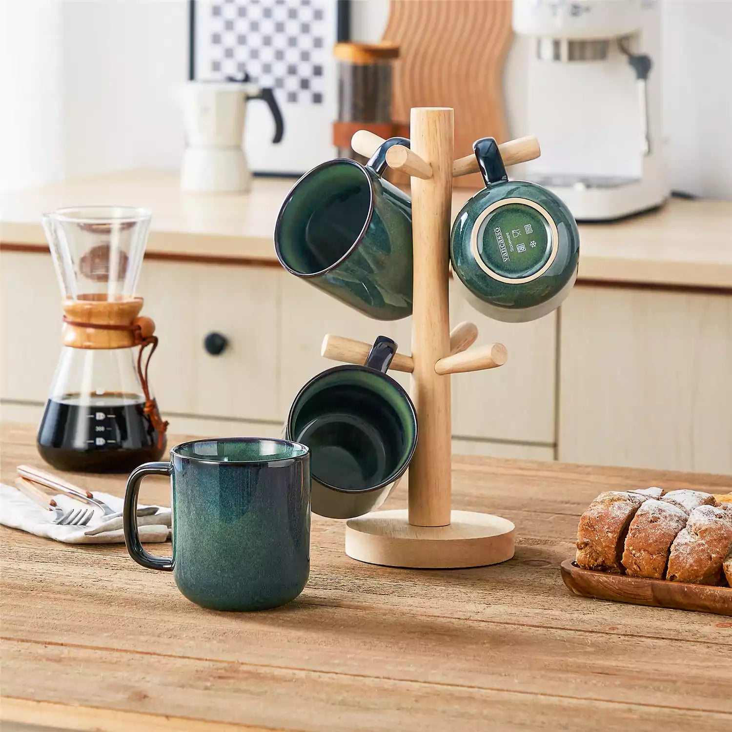 Four starry green 16oz stoneware mugs with latte art on wooden table beside coffee brewing equipment