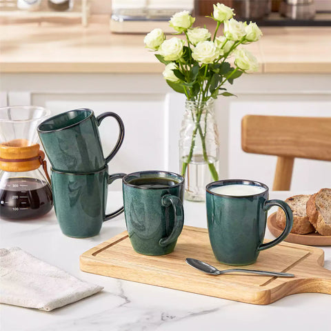 Green Starry 12oz stoneware mugs set of 4 with reactive glaze finish on a kitchen counter with coffee milk and fresh bread