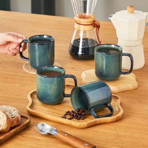 Starry teal 12oz stoneware mugs set of 4 with coffee on wooden table next to coffee maker and fresh bread cozy breakfast scene