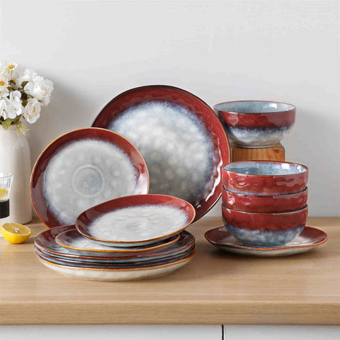 Starry 12-piece stoneware dinnerware set in red on a light wooden table - styled with lamb chops - pastries - coffee pot - and lemon water for a cozy farmhouse breakfast scene