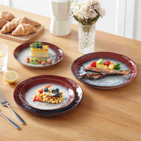 Starry 12-piece stoneware dinnerware set in red on a light wooden table - styled with lamb chops - pastries - coffee pot - and lemon water for a cozy farmhouse breakfast scene