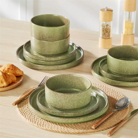 Green reactive glaze stoneware dinner plates styled with food on rustic wood table with woven placemats modern minimalist tableware set